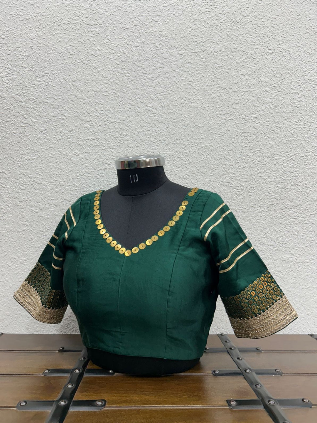 Green blouse with tiki work detailing on a neckline and sleeve