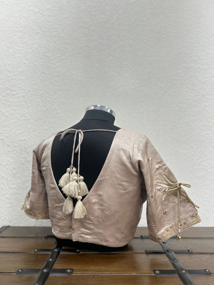 Elegant festive blouse showcasing lotus-inspired sleeve embroidery with delicate dori accents