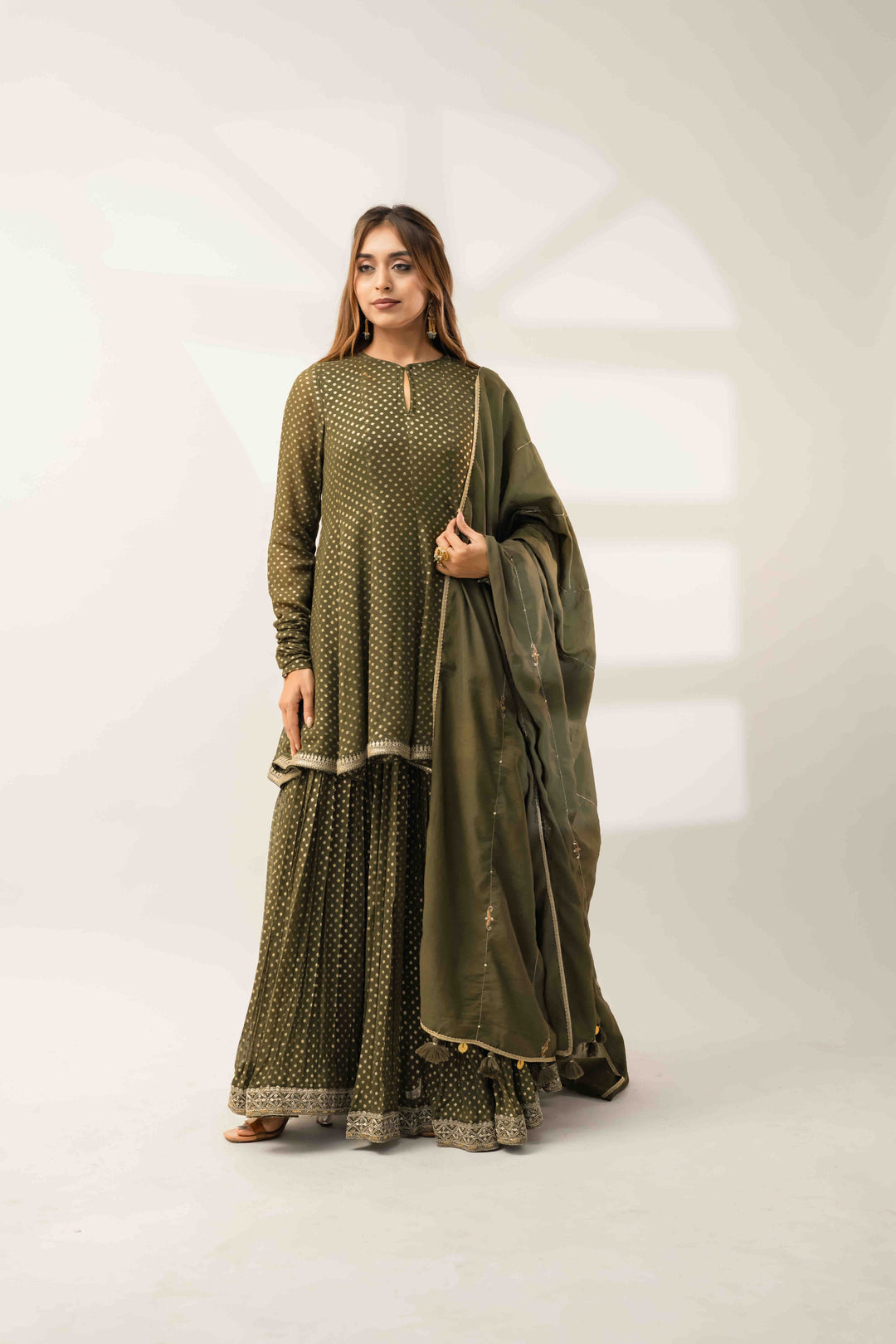 A designer Indo-Western silhouette in olive green featuring a voluminous flared Anarkali top paired with a matching dupatta, showcasing premium ethnic fusion wear from Pōhi Studio Ahmedabad.