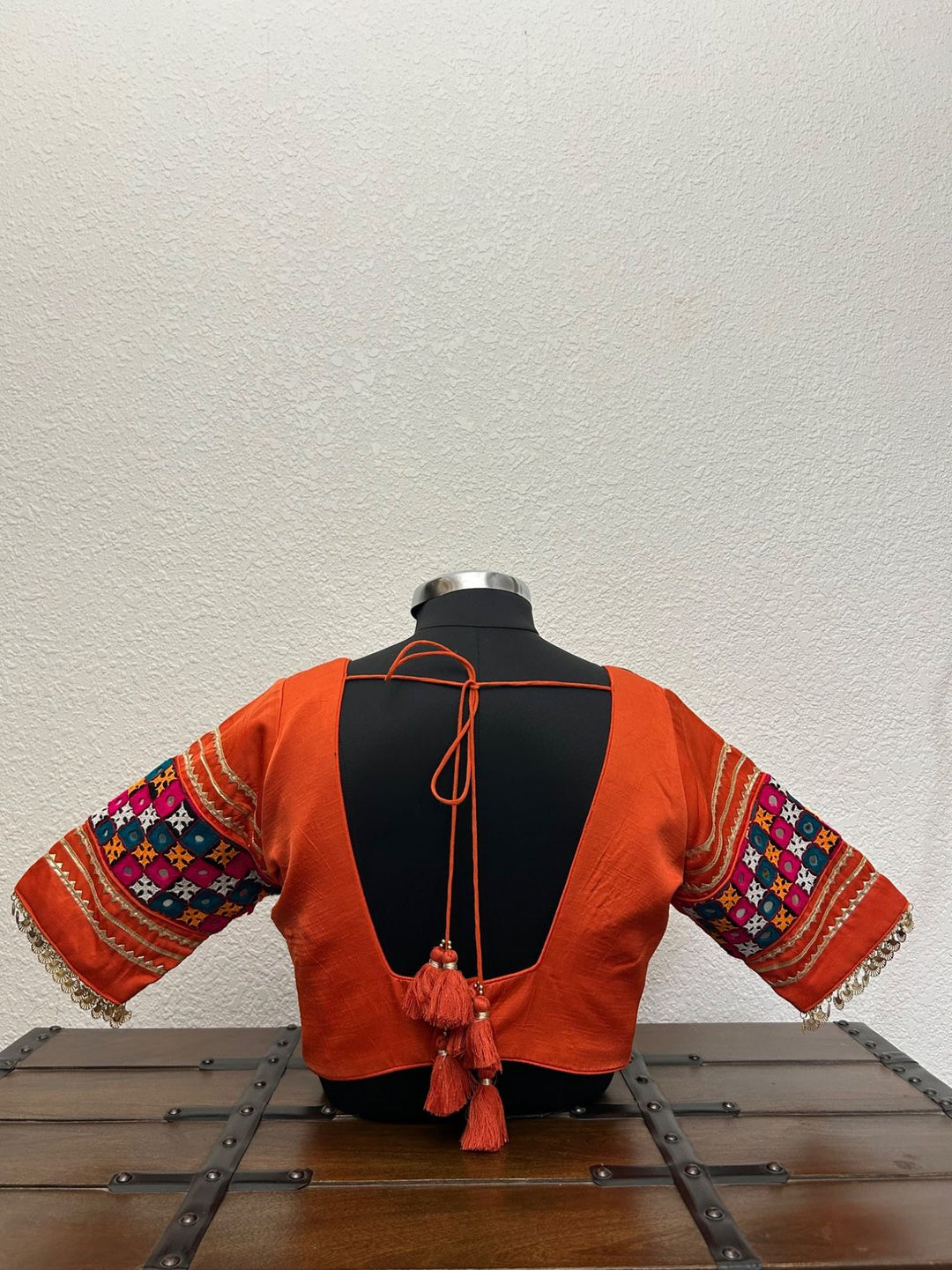 Traditional orange festive blouse with colorful embroidered sleeves