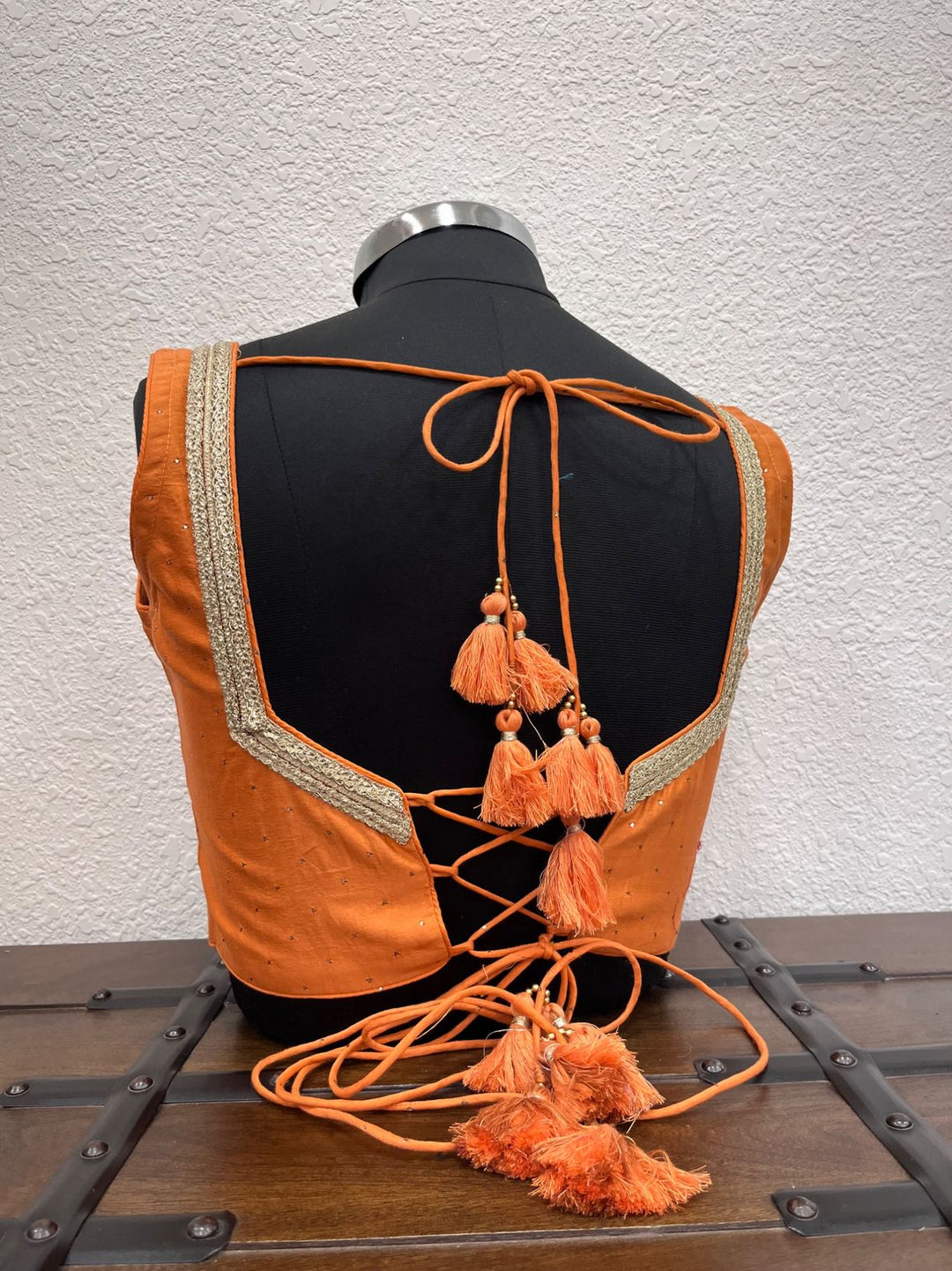 Festive orange designer blouse with handcrafted Mukesh work accents
