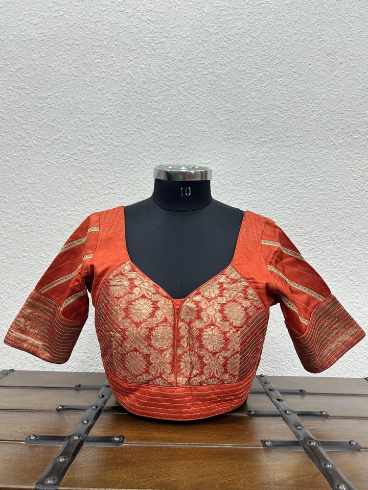 Orange raw silk satin blouse with Banarasi fabric and handcrafted kasab work on the front